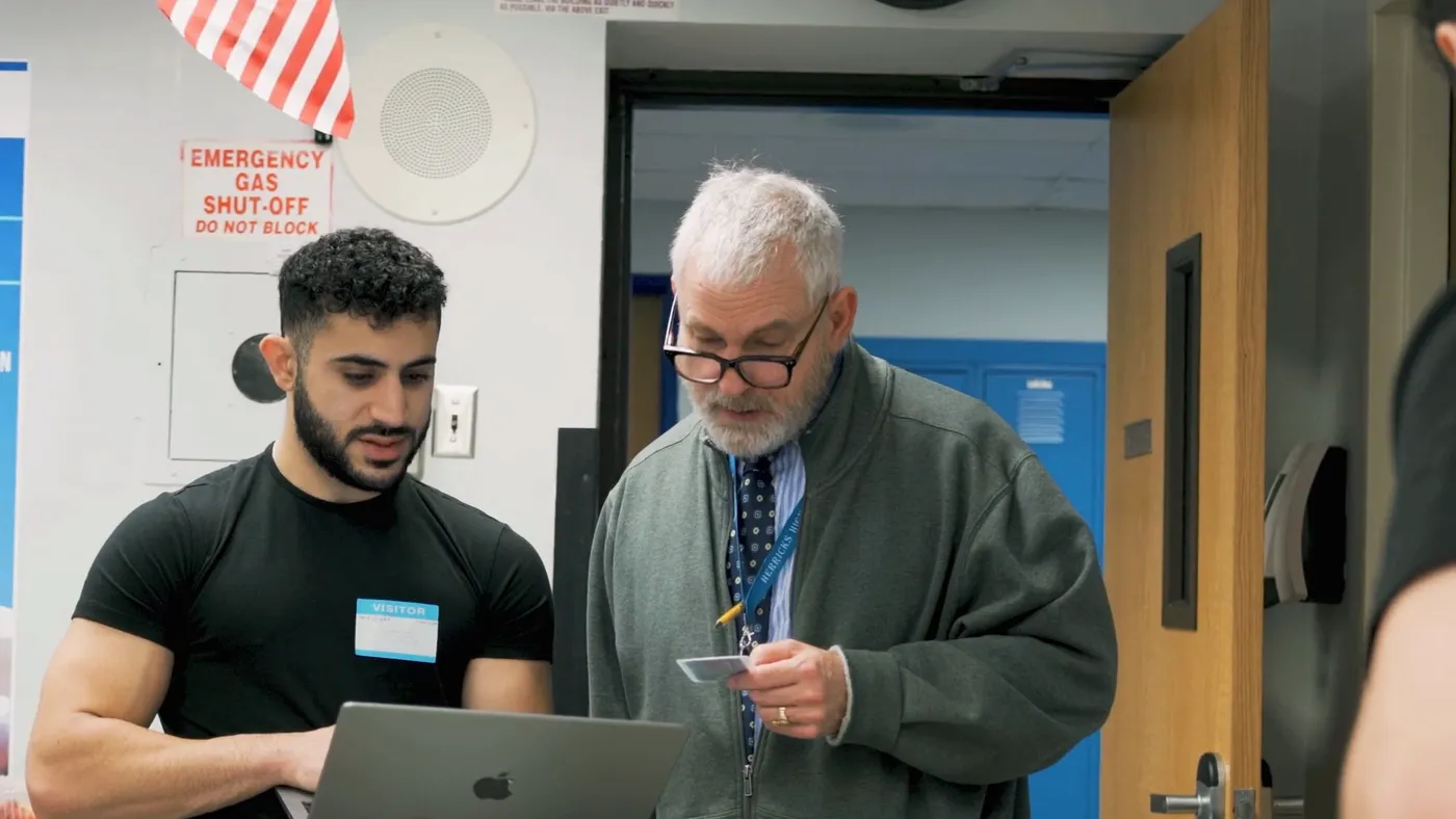 A ReGlow team member checking in a school staff member on a laptop