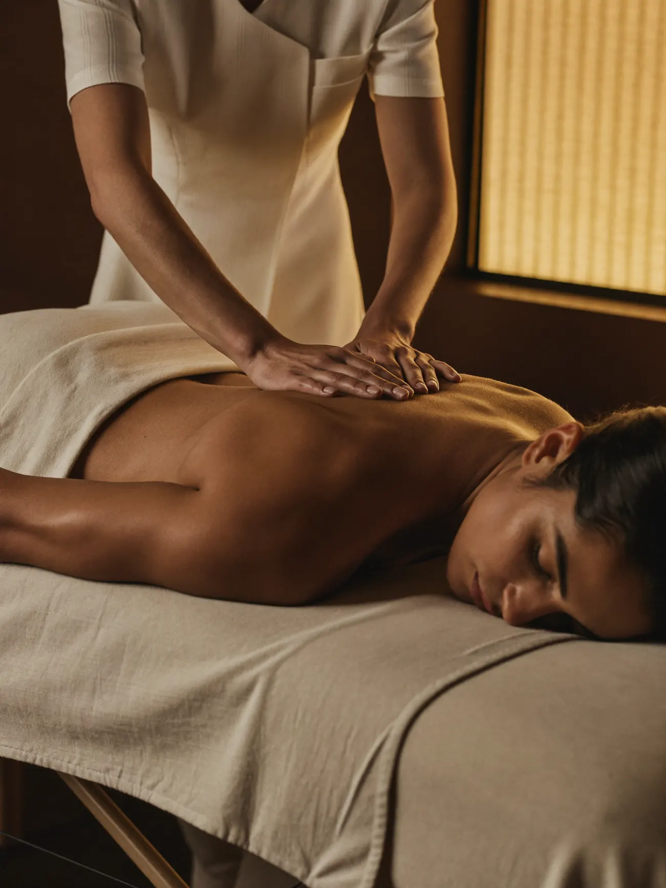 Therapist delivering targeted medical massage in a warm, calm treatment room
